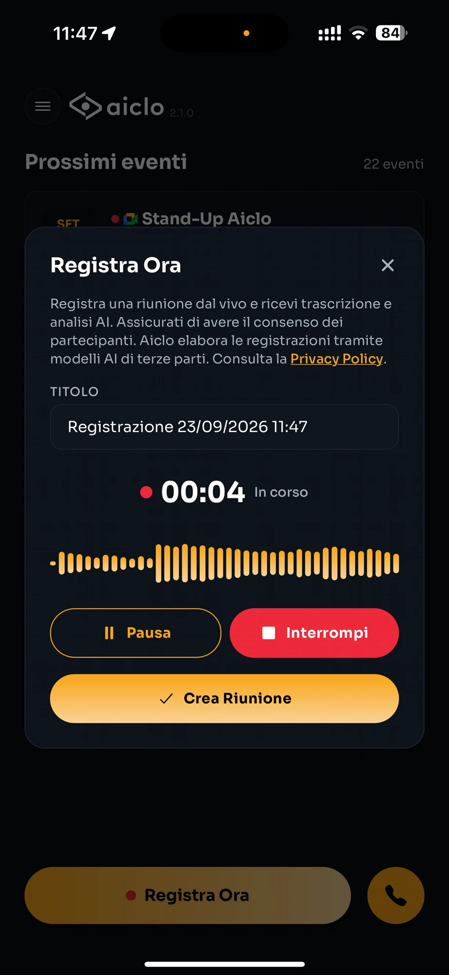 L’app Aiclo durante la registrazione di una riunione dal vivo: timer 00:04 in corso, forma d’onda ambra, pulsanti Pausa, Interrompi e Crea Riunione.
